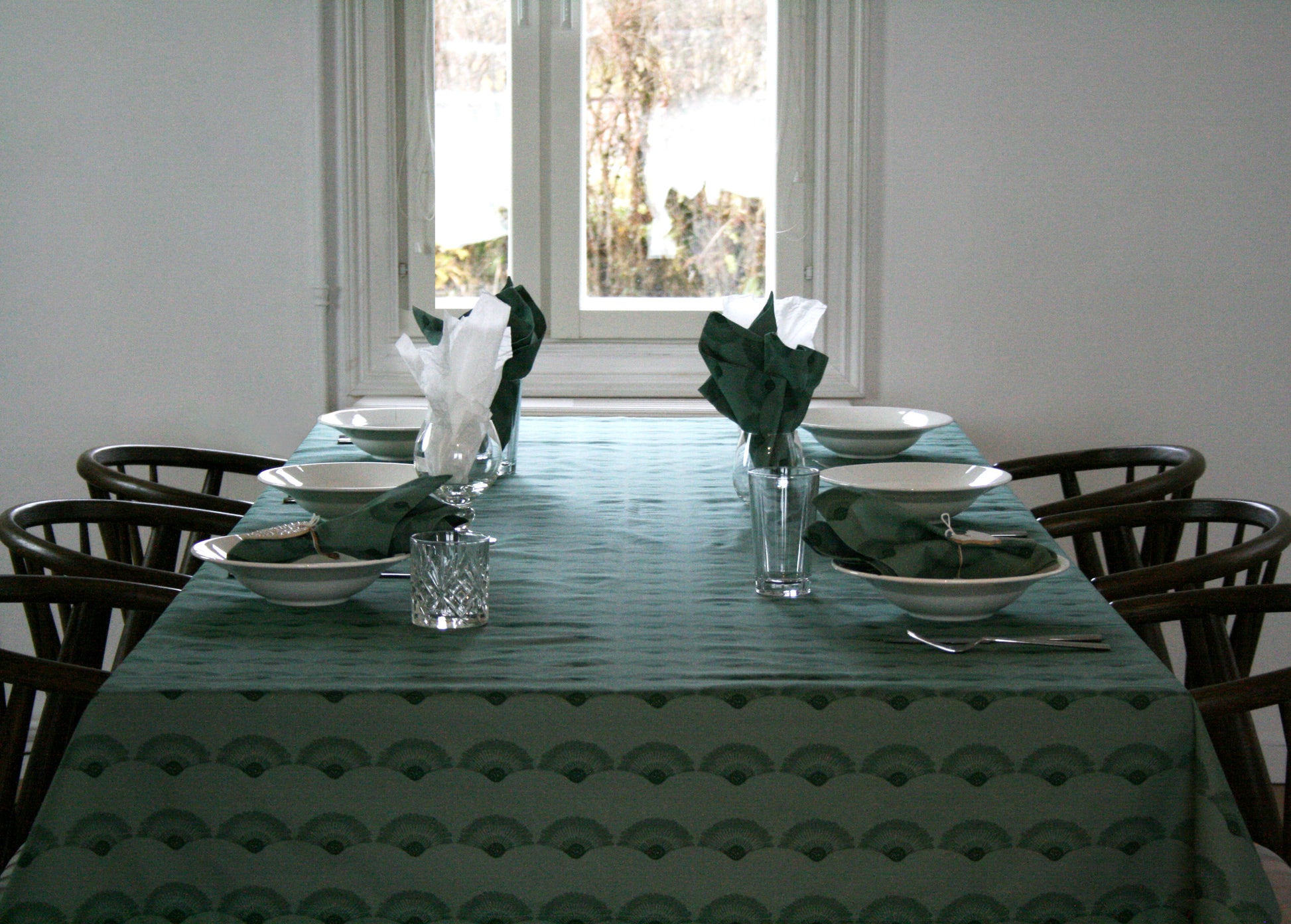 Bordsduk Solfjäder Bomull Skogsgrön 140x240 cm, miljöbild. Dukat bord med bordsduk, servetter, tallrikar, glas och bestick.
