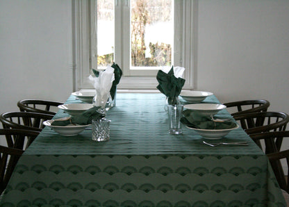 Bordsduk Solfjäder Bomull Skogsgrön 140x240 cm, miljöbild. Dukat bord med bordsduk, servetter, tallrikar, glas och bestick.