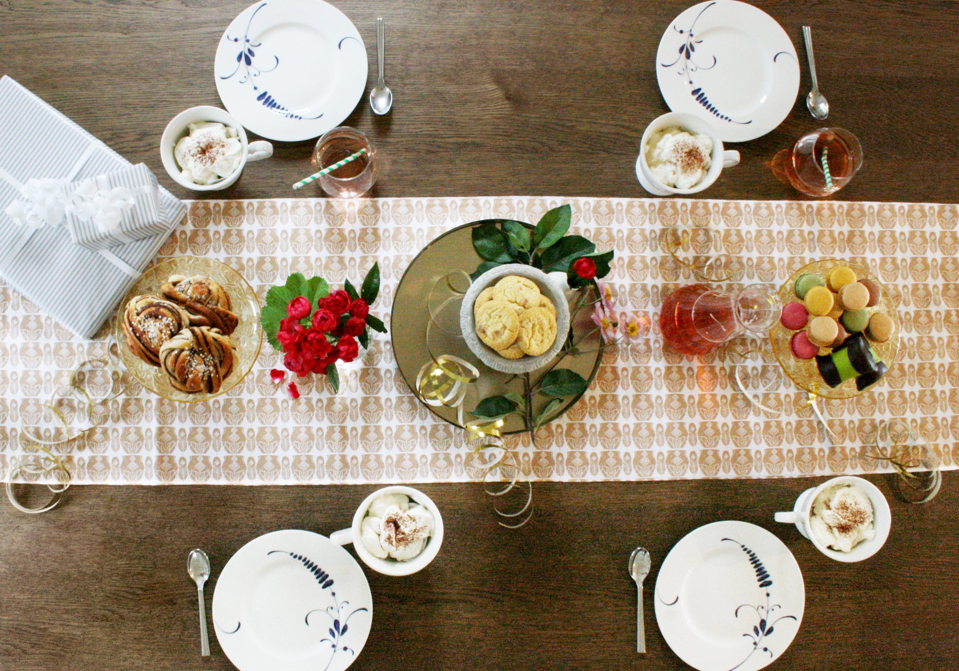 Geometrisk bordslöpare terracotta 40×140 - repetitivt turkost och vitt fjäder- och krukmönster på vit bakgrund, miljöbild