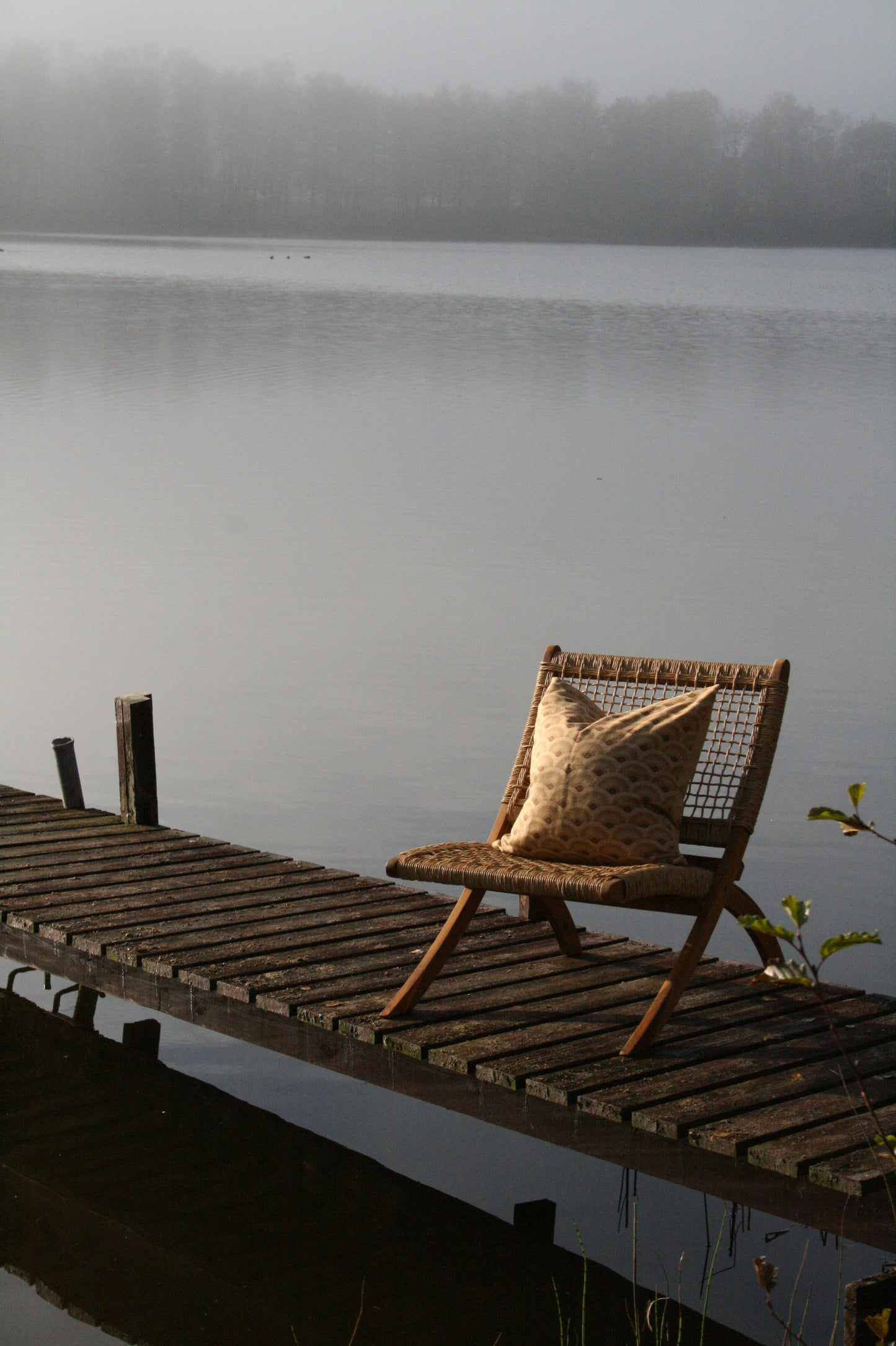 Kuddfodral Vågor Linneblandning Soft Gold 50x50, miljöbild. Kudde på stol ute på brygga.