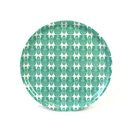kruka-fjader-serveringsbricka-turkos-nordisk-design - rund serveringsbricka med upprepat mönster i turkosa toner för nordisk servering på vit bakgrund
